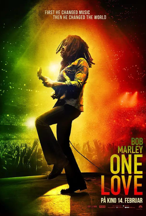 Mężczyzna z gitarą na scenie. Tłum pod sceną. Światła zielone, żółte i czerwone. Tekst: Bob Marley, One Love